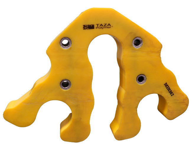 Una pieza de poliuretano de alta resistencia de color amarillo brillante con una forma compleja y múltiples orificios para tornillos con ojales metálicos. La pieza tiene un diseño simétrico con dos grandes orificios en la parte inferior y dos curvaturas en la parte superior. La superficie lleva las inscripciones "TAZA Polymer" y "MIN36Z". La imagen está tomada sobre un fondo blanco.