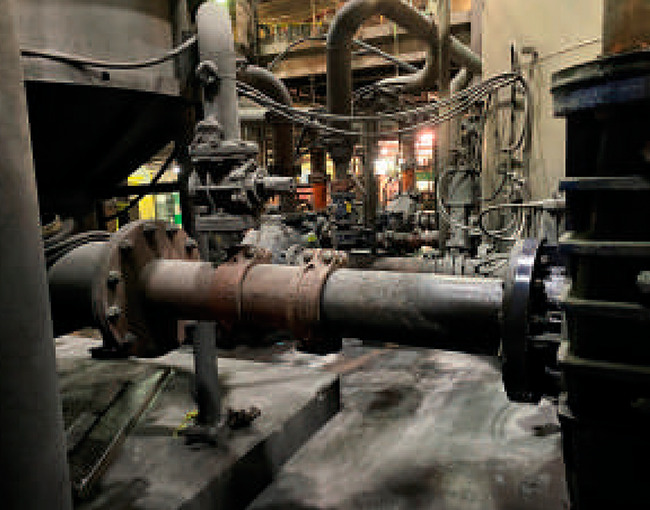 Red de tuberías industriales y bridas en una planta de procesamiento, mostrando el entorno de trabajo de TAZA.