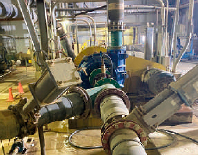 Complejo sistema de tuberías y bombas industriales interconectadas en una planta de tratamiento de aguas o proceso minero.