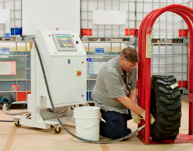 Técnico de TAZA Polymer utilizando equipo de llenado con poliuretano para llantas industriales.