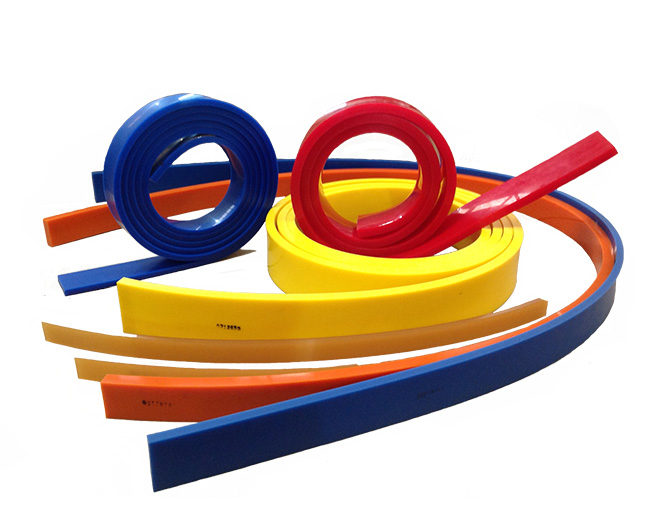 Tiras de polímero de ingeniería de colores rojo, amarillo, naranja y azul, enrolladas para mostrar su flexibilidad y elasticidad.