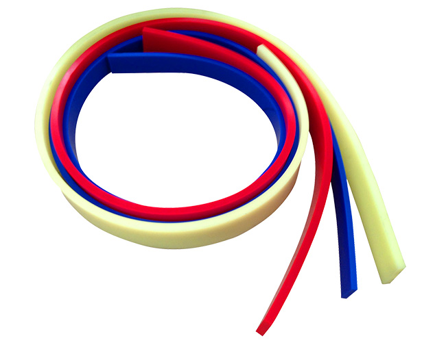 Tiras de polímero de ingeniería de colores beige, rojo y azul, enrolladas para mostrar su flexibilidad y elasticidad.