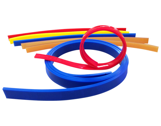 Tiras de polímero de ingeniería de colores rojo, amarillo, naranja y azul, enrolladas para mostrar su flexibilidad y elasticidad.