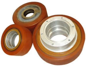 Conjunto de tres rodillos industriales de diferentes tamaños, con un revestimiento exterior de polímero de color naranja-rojizo sobre un núcleo metálico.