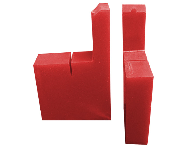 Dos piezas industriales de polímero de color rojo, con forma angular, diseñadas como revestimientos o protectores para maquinaria.